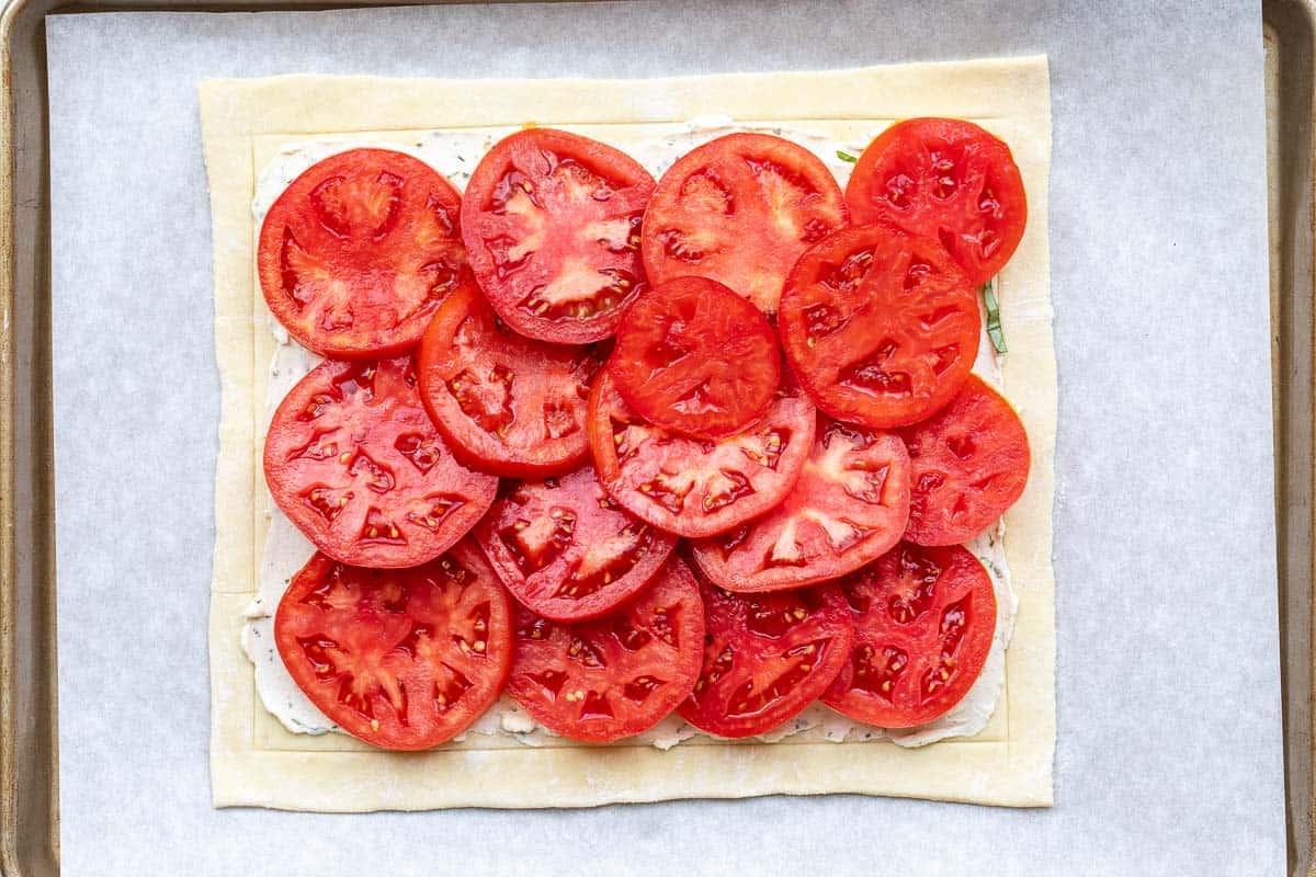 tomatoes arranged on Boursin covered sheet of puff pastry dough.