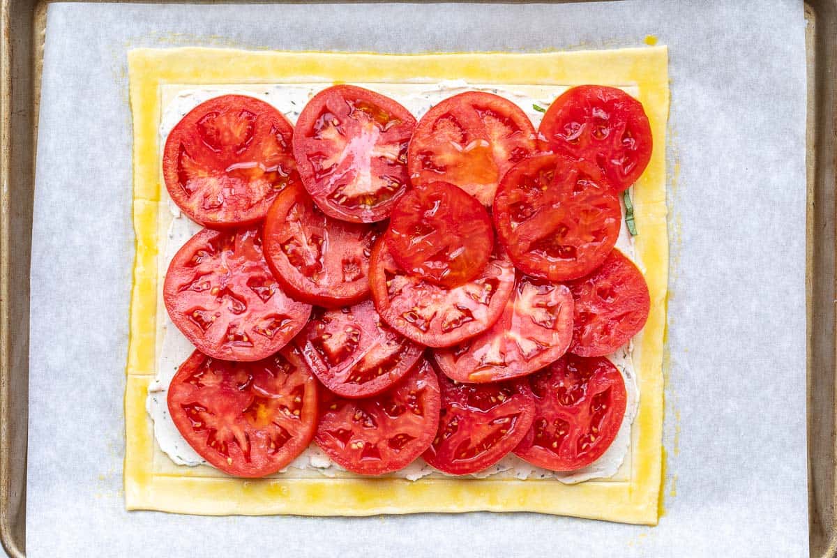 puff pastry tomato tart on sheet pan ready for oven.