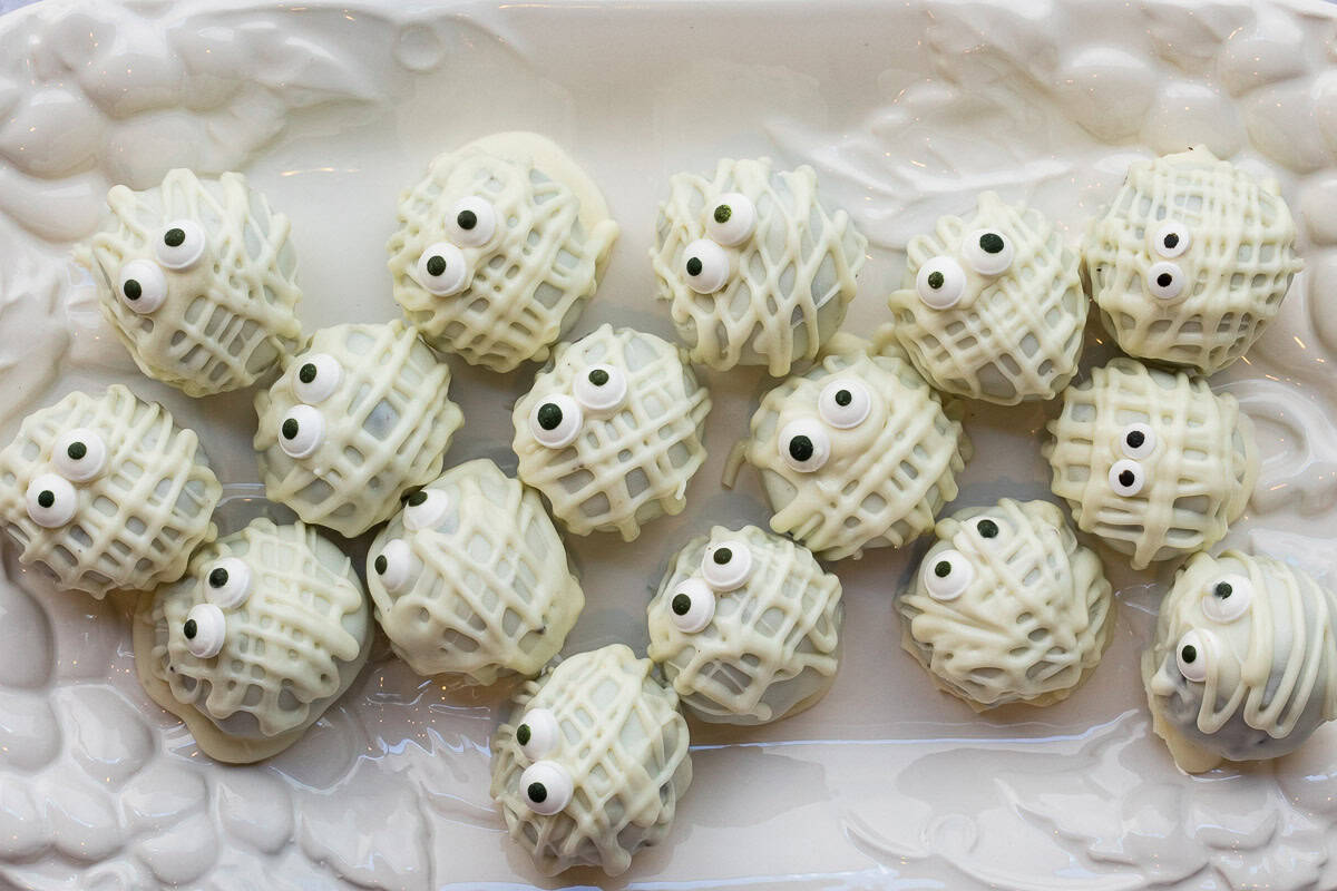 halloween mummy truffles on a white tray.