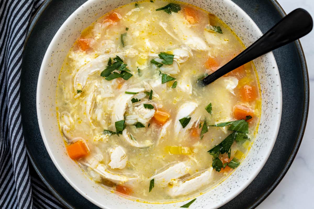 bowl of chicken soup with rice and lemon.