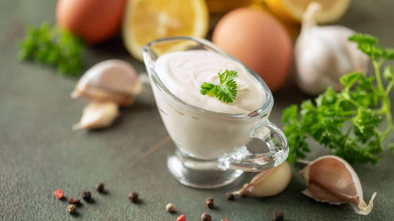 Garlic Aioli sauce in bowl and ingredients on the table