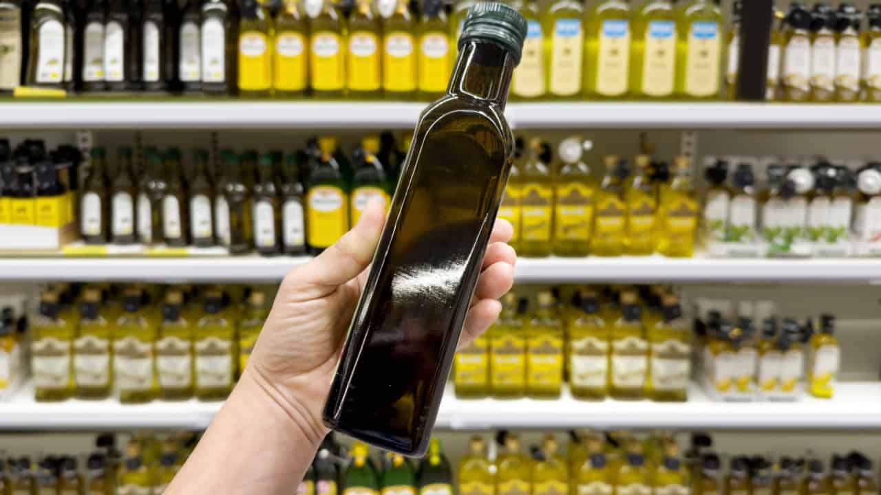 choosing olive oil, sauce, vinegar at the grocery store
