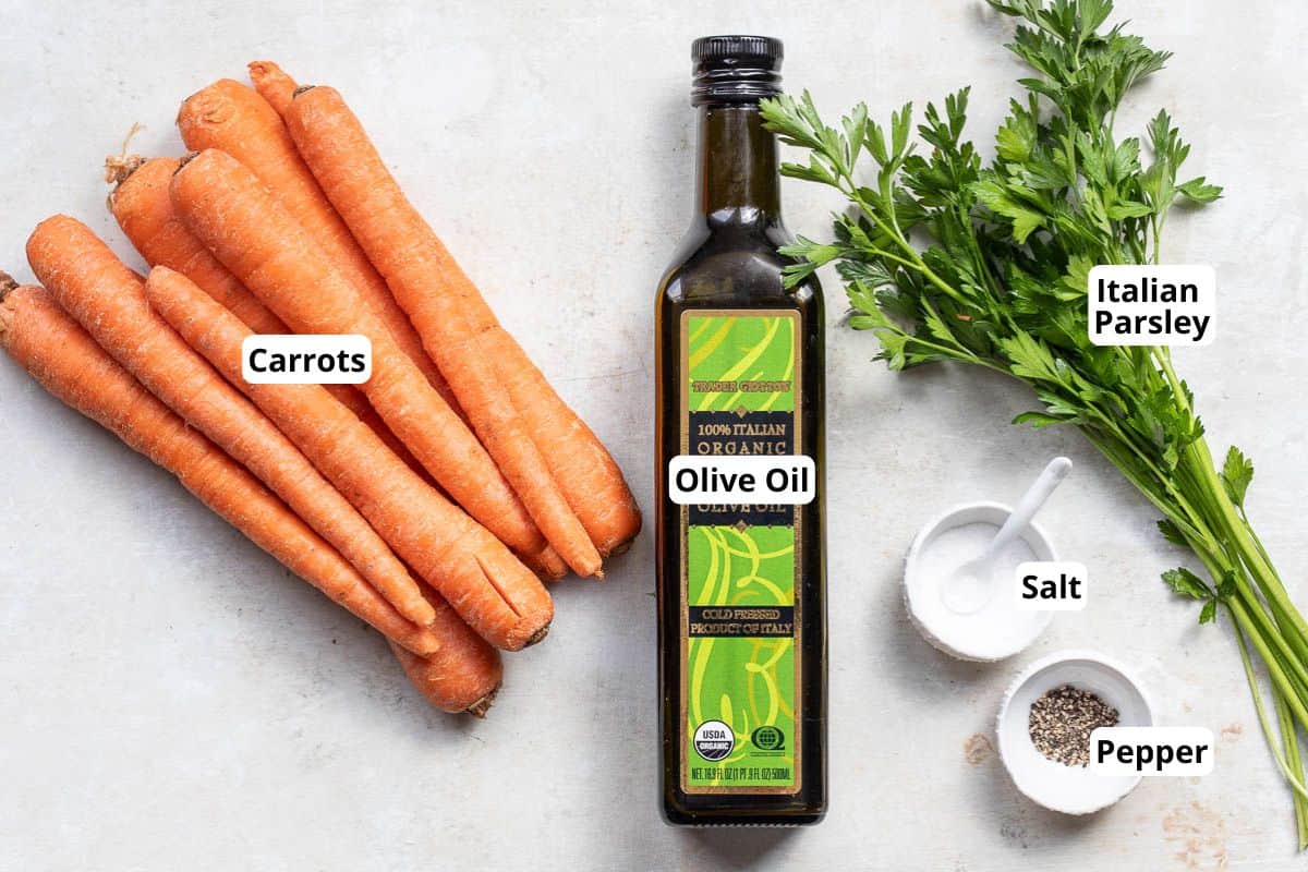 A bunch of carrots, a bottle of olive oil, fresh Italian parsley, a bowl of salt, and a bowl of pepper are arranged on a light surface. Labels identify each item.