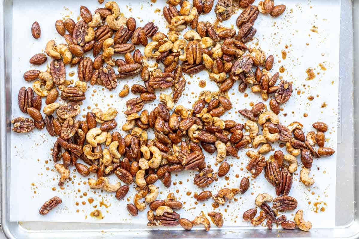 Honey roasted nuts on parchment-lined sheet pan after baking.