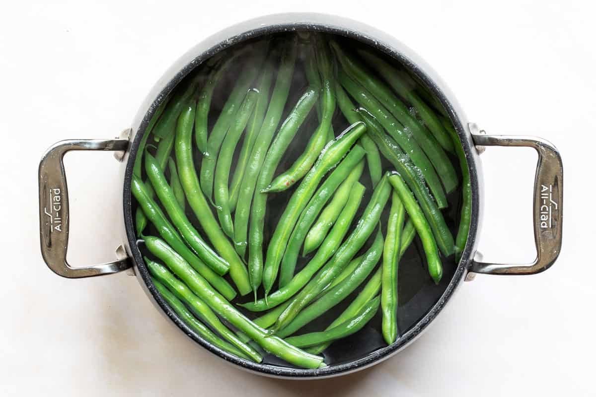 Green beans boiling in an All-Clad pot.